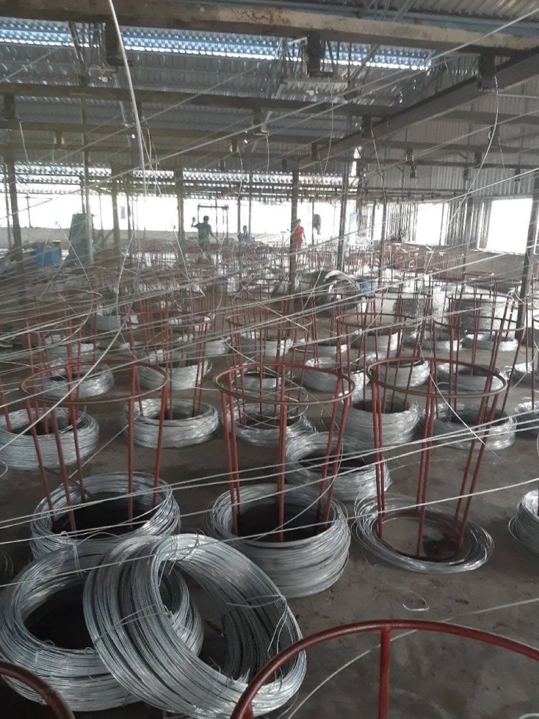 Coils of raw wire staged on the factory floor before processing